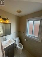 Bathroom featuring tile patterned flooring, vanity, toilet, and tile walls - 