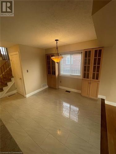 Unfurnished dining area with light hardwood / wood-style floors and a textured ceiling - 126 Peach Blossom Crescent, Kitchener, ON - Indoor Photo Showing Other Room