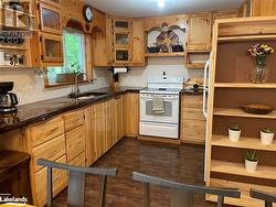 Kitchen featuring white range with electric stovetop, dark hardwood / wood-style flooring, and sink - 