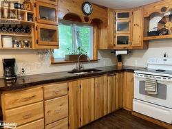 Kitchen with white electric range oven, dark wood-type flooring, and sink - 