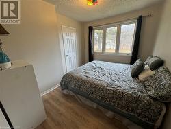 Bedroom with light hardwood / wood-style floors and a textured ceiling - 