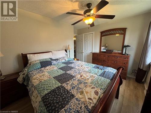 Bedroom featuring ceiling fan, a closet, wood-type flooring, and a textured ceiling - 3877 Hwy 17 E, Mattawa, ON - Indoor Photo Showing Bedroom