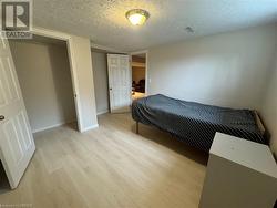 Bedroom with light hardwood / wood-style floors and a textured ceiling - 