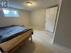 Bedroom featuring light hardwood / wood-style flooring and a textured ceiling - 