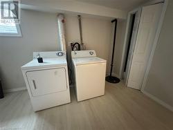 Laundry area featuring independent washer and dryer and light wood-type flooring - 