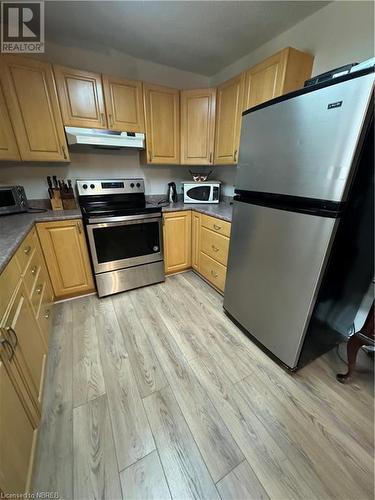 Kitchen featuring stainless steel stove, light hardwood / wood-style flooring, extractor fan, and fridge - 3877 Hwy 17 E, Mattawa, ON - Indoor Photo Showing Kitchen