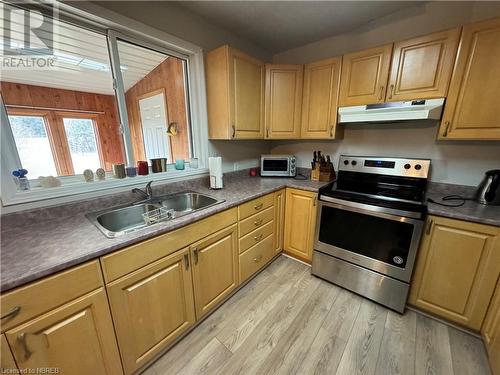 Kitchen featuring electric range, vaulted ceiling, sink, and light hardwood / wood-style flooring - 3877 Hwy 17 E, Mattawa, ON - Indoor Photo Showing Kitchen With Double Sink