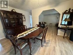 Dining area with light wood-type flooring and a textured ceiling - 