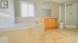 Full bathroom featuring tile patterned flooring, vanity, independent shower and bath, and toilet - 