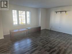 Empty room with dark wood-type flooring - 