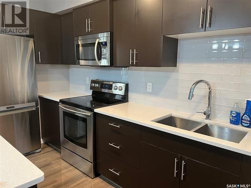 1 4545 Delhaye Way, Regina, SK - Indoor Photo Showing Kitchen With Stainless Steel Kitchen With Double Sink With Upgraded Kitchen