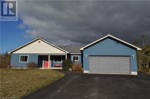 Single story home featuring covered porch, a garage, and a front yard - 1 Williamson Place, South Bruce Peninsula, ON - Outdoor