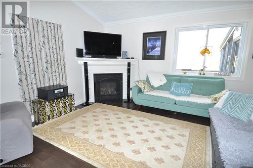 Living room with a textured ceiling, wood-type flooring, ornamental molding, and vaulted ceiling - 1 Williamson Place, South Bruce Peninsula, ON - Indoor Photo Showing Living Room With Fireplace