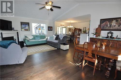 Dining area with ornamental molding, ceiling fan , dark engineered hardwood flooring, and lofted ceiling - 1 Williamson Place, South Bruce Peninsula, ON - Indoor Photo Showing Living Room With Fireplace