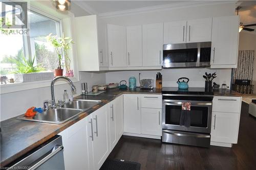 Kitchen featuring sink, dark engineered hardwood flooring, crown molding, white cabinets, and appliances with stainless steel finishes - 1 Williamson Place, South Bruce Peninsula, ON - Indoor Photo Showing Kitchen With Double Sink With Upgraded Kitchen