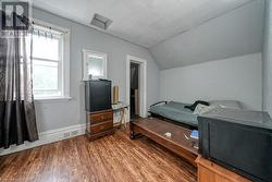 Bedroom featuring multiple windows, vaulted ceiling, and hardwood / wood-style flooring - 