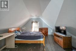 Bedroom featuring dark hardwood / wood-style flooring and lofted ceiling - 