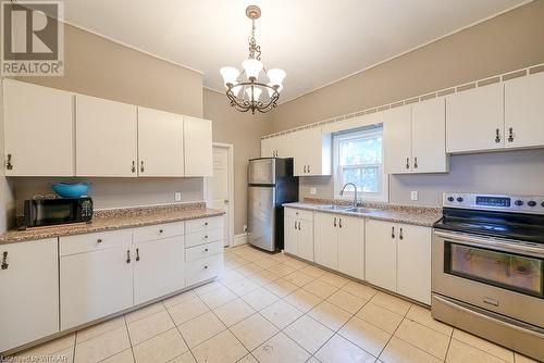 Kitchen featuring white cabinets, appliances with stainless steel finishes, hanging light fixtures, and sink - 742 Dundas Street, Woodstock, ON - Indoor Photo Showing Kitchen With Double Sink