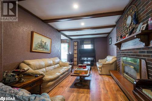 Living room with hardwood / wood-style floors, a brick fireplace, and beam ceiling - 48 North Trent Street, Frankford, ON - Indoor Photo Showing Living Room With Fireplace