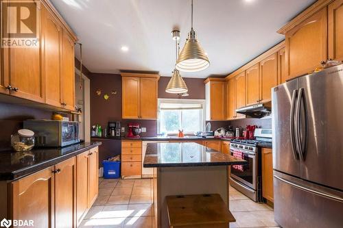 Kitchen featuring appliances with stainless steel finishes, a kitchen island, hanging light fixtures, and light tile patterned flooring - 48 North Trent Street, Frankford, ON - Indoor Photo Showing Kitchen