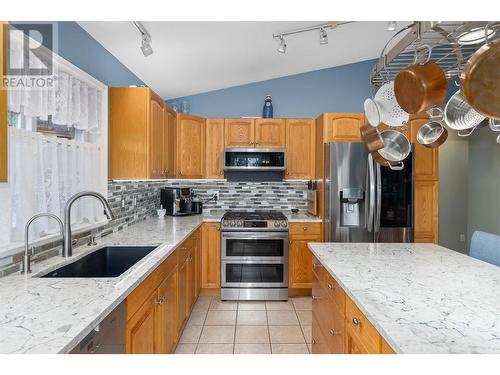 Kitchen with updated appliances and large island - 1650 Wilmot Court, Kelowna, BC - Indoor Photo Showing Kitchen