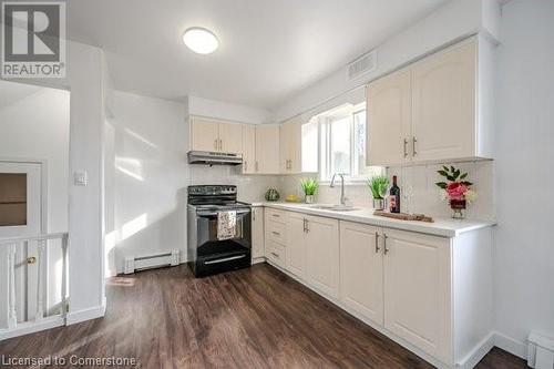 Kitchen with black electric range, tasteful backsplash, a baseboard heating unit, and sink - 175 Cedarbrae Avenue, Waterloo, ON - Indoor Photo Showing Kitchen