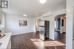 Kitchen with baseboard heating, stainless steel fridge, and dark hardwood / wood-style floors - 