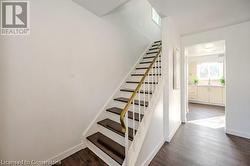 Stairs with hardwood / wood-style floors and sink - 