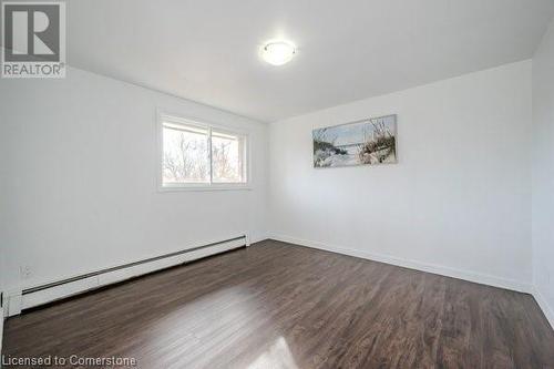 Spare room with dark hardwood / wood-style floors and baseboard heating - 175 Cedarbrae Avenue, Waterloo, ON - Indoor Photo Showing Other Room