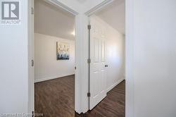 Hallway featuring dark wood-type flooring - 