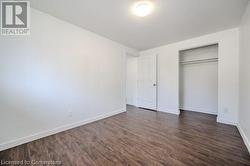 Unfurnished bedroom featuring a closet and dark hardwood / wood-style flooring - 