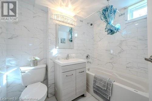 Bathroom featuring a bathing tub, vanity, toilet, and tile walls - 175 Cedarbrae Avenue, Waterloo, ON - Indoor Photo Showing Bathroom