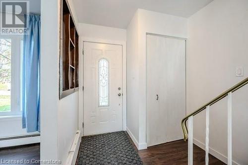 Entryway featuring plenty of natural light, dark hardwood / wood-style floors, and a baseboard heating unit - 175 Cedarbrae Avenue, Waterloo, ON - Indoor Photo Showing Other Room