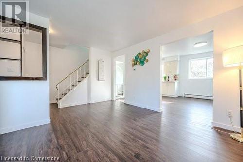 Unfurnished living room with dark hardwood / wood-style flooring and baseboard heating - 175 Cedarbrae Avenue, Waterloo, ON - Indoor