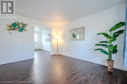 Empty room featuring a baseboard radiator and dark hardwood / wood-style floors - 175 Cedarbrae Avenue, Waterloo, ON - Indoor Photo Showing Other Room