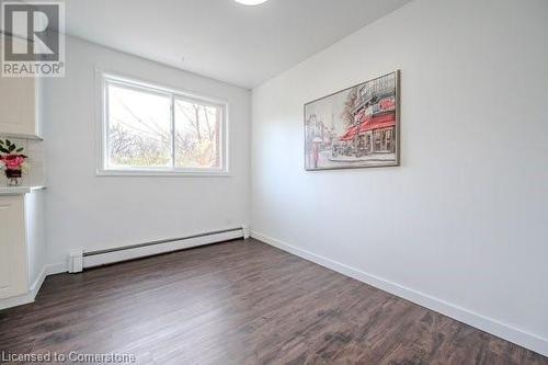 Unfurnished room with baseboard heating and dark wood-type flooring - 175 Cedarbrae Avenue, Waterloo, ON - Indoor Photo Showing Other Room