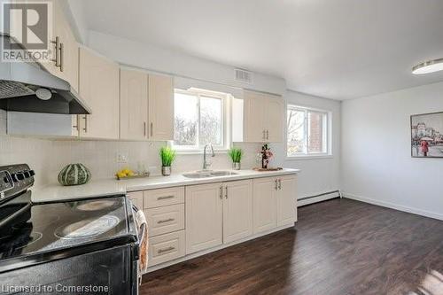 Kitchen featuring dark hardwood / wood-style floors, black range with electric stovetop, sink, and a baseboard radiator - 175 Cedarbrae Avenue, Waterloo, ON - Indoor Photo Showing Kitchen