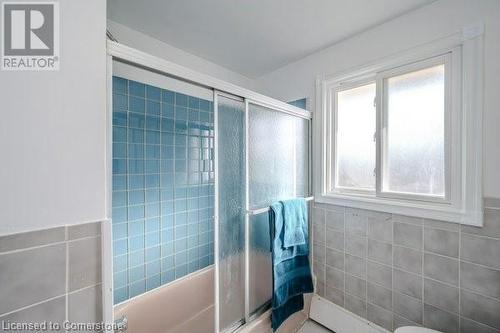 Bathroom featuring tiled shower / bath combo and tile walls - 175 Cedarbrae Avenue, Waterloo, ON - Indoor Photo Showing Bathroom