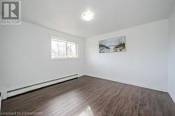 Spare room with dark hardwood / wood-style floors and baseboard heating - 