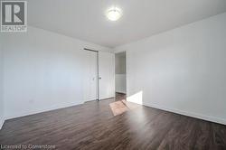 Empty room with dark wood-type flooring - 