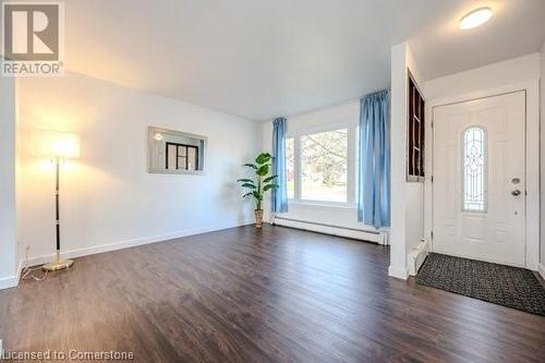 Foyer with dark hardwood / wood-style floors and a baseboard heating unit - 175 Cedarbrae Avenue, Waterloo, ON - Indoor