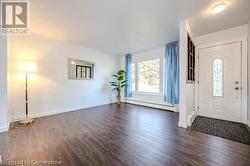 Foyer with dark hardwood / wood-style floors and a baseboard heating unit - 