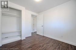 Unfurnished bedroom featuring dark hardwood / wood-style flooring and a closet - 