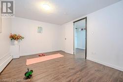 Workout room with a textured ceiling, hardwood / wood-style flooring, and a baseboard heating unit - 