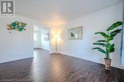 Empty room featuring a baseboard radiator and dark hardwood / wood-style floors - 