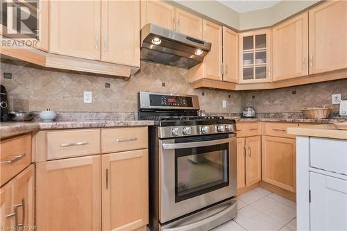 Kitchen featuring backsplash, gas range, light brown cabinets, and light tile patterned floors - 613 Black Street, Fergus, ON - Indoor Photo Showing Kitchen