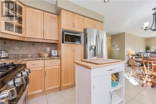 Kitchen with decorative backsplash, light brown cabinets, pendant lighting, and appliances with stainless steel finishes - 613 Black Street, Fergus, ON - Indoor Photo Showing Kitchen