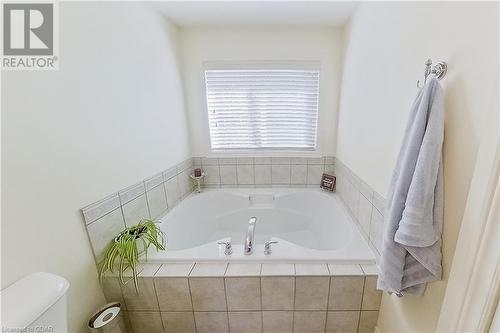 Bathroom with a relaxing tiled tub and toilet - 613 Black Street, Fergus, ON - Indoor Photo Showing Bathroom