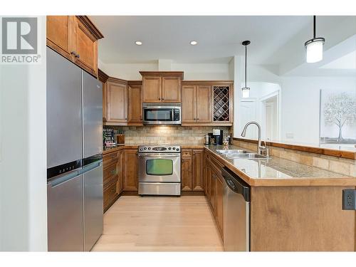 Beautiful kitchen with granite tile counters, eating bar, stainless steel appliances (newer fridge) - 2770 Auburn Road Unit# 201, West Kelowna, BC - Indoor Photo Showing Kitchen With Stainless Steel Kitchen With Double Sink