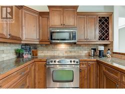 Beautiful kitchen with granite tile counters, eating bar, stainless steel appliances (newer fridge) - 